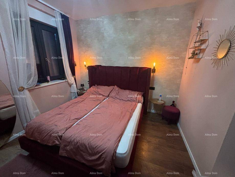 Schlafzimmer mit rotem Doppelbett, Nachttischen und dekorativen Wandleuchten, gemütlich beleuchtet.