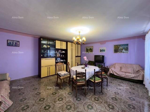 Gemütliches Wohn-Esszimmer mit lila Wänden, traditionellen Möbeln und einem kleinen Fernseher.
