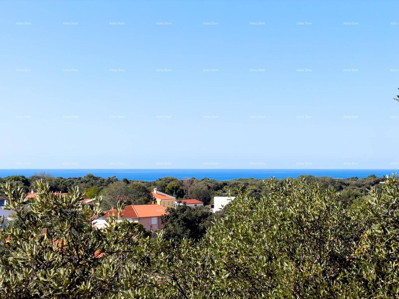 Weitläufiger Blick auf das blaue Meer und die grüne Küstenlandschaft mit vereinzelten Häusern.