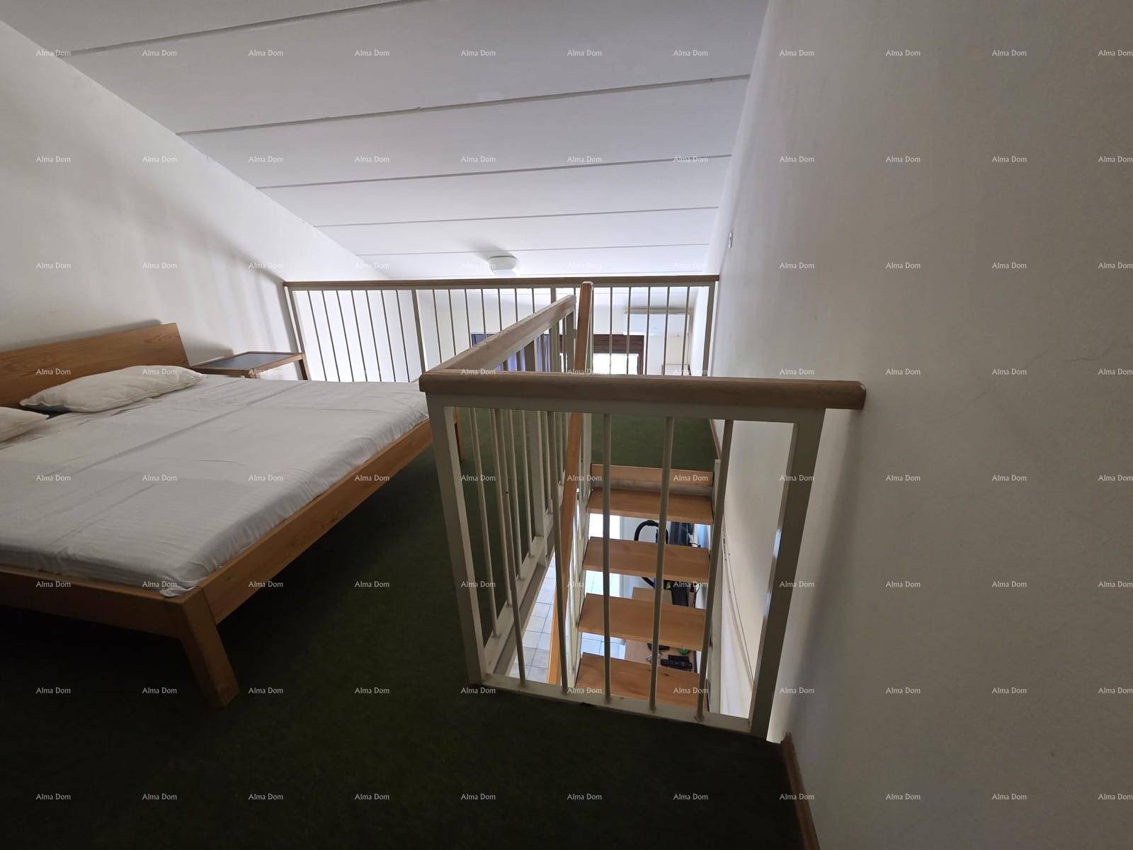 Schlafbereich auf der Empore mit Doppelbett und Geländer, das den Blick nach unten freigibt.