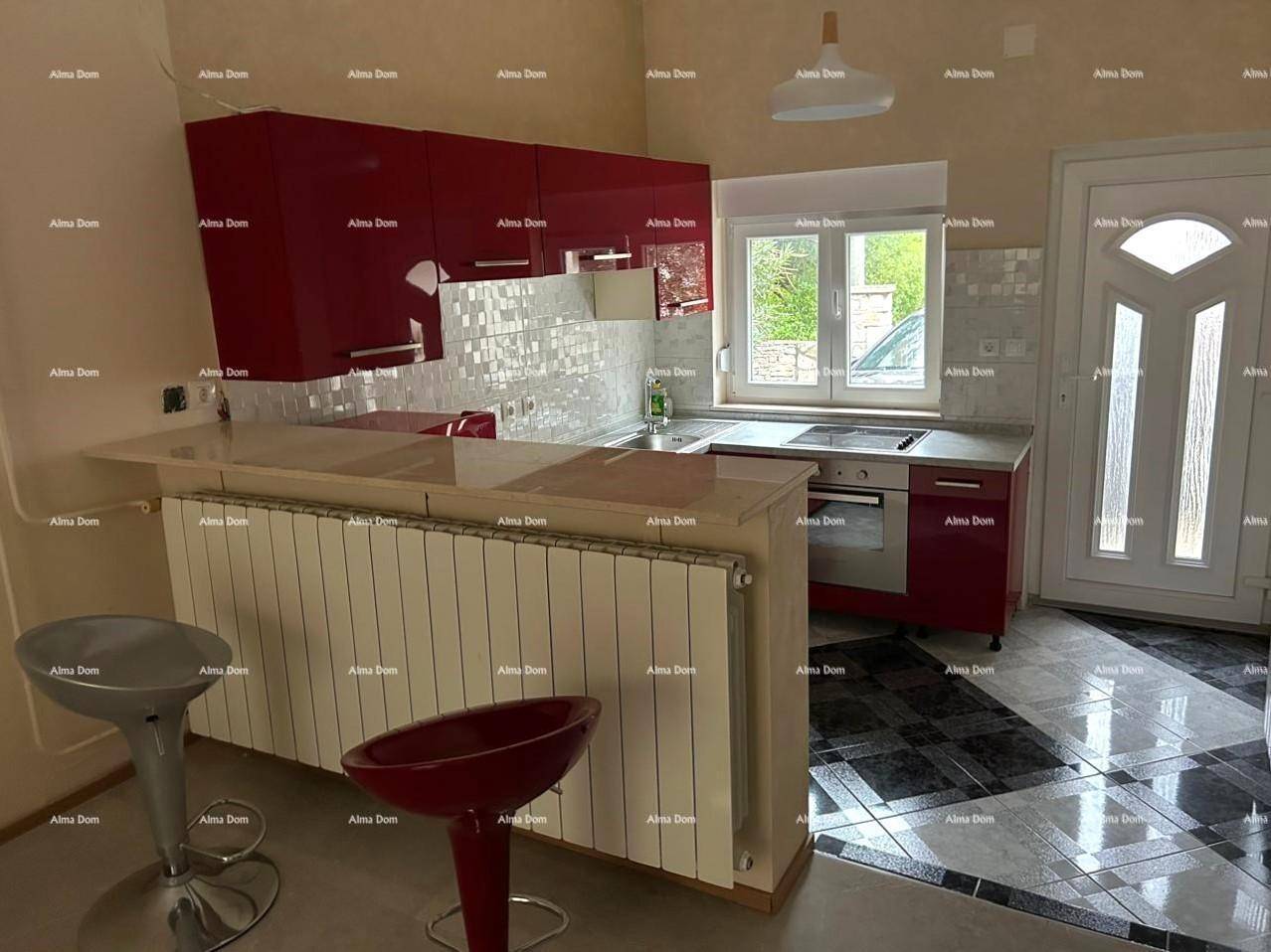 Moderne Küche mit roten Hochglanzschränken, Frühstücksbar und gemusterten Bodenfliesen.