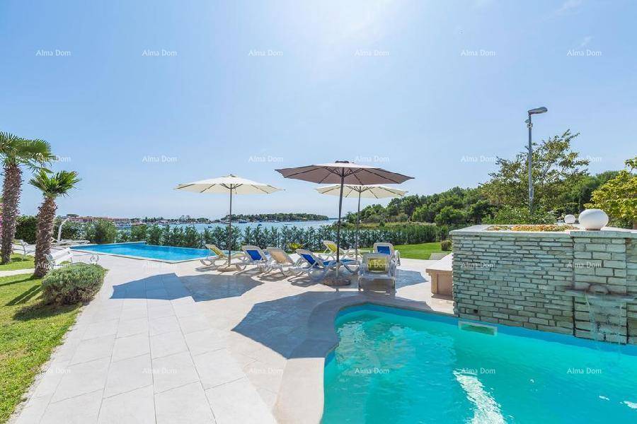 Zwei Pools im Außenbereich mit Liegeflächen, Sonnenschirmen und einem weiten Blick auf das Meer.