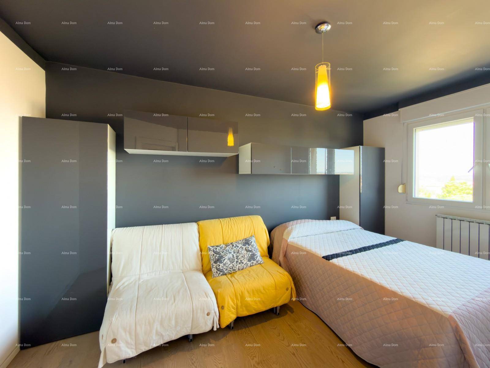 Schlafzimmer mit Doppelbett, gelbem Sofa und modernen Schränken in dunklem Grau.