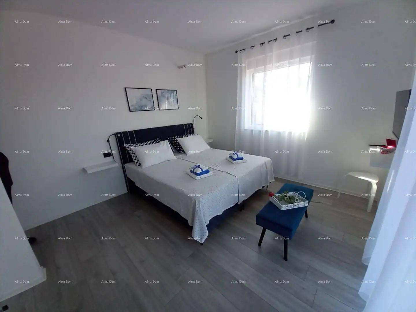 Modernes Schlafzimmer mit Doppelbett, Fenster und schlichtem, hellem Design.