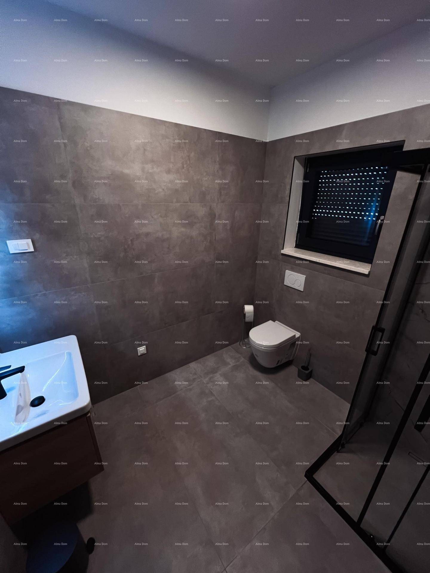 Modernes Badezimmer mit dunklen Fliesen, Dusche und Fenster mit Rollladen.