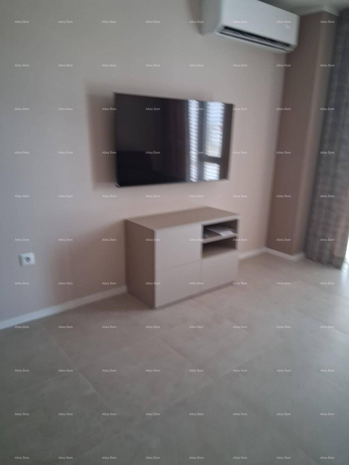 Heller Wohnbereich mit montiertem Fernseher, minimalistischem Möbelstück und Klimaanlage.