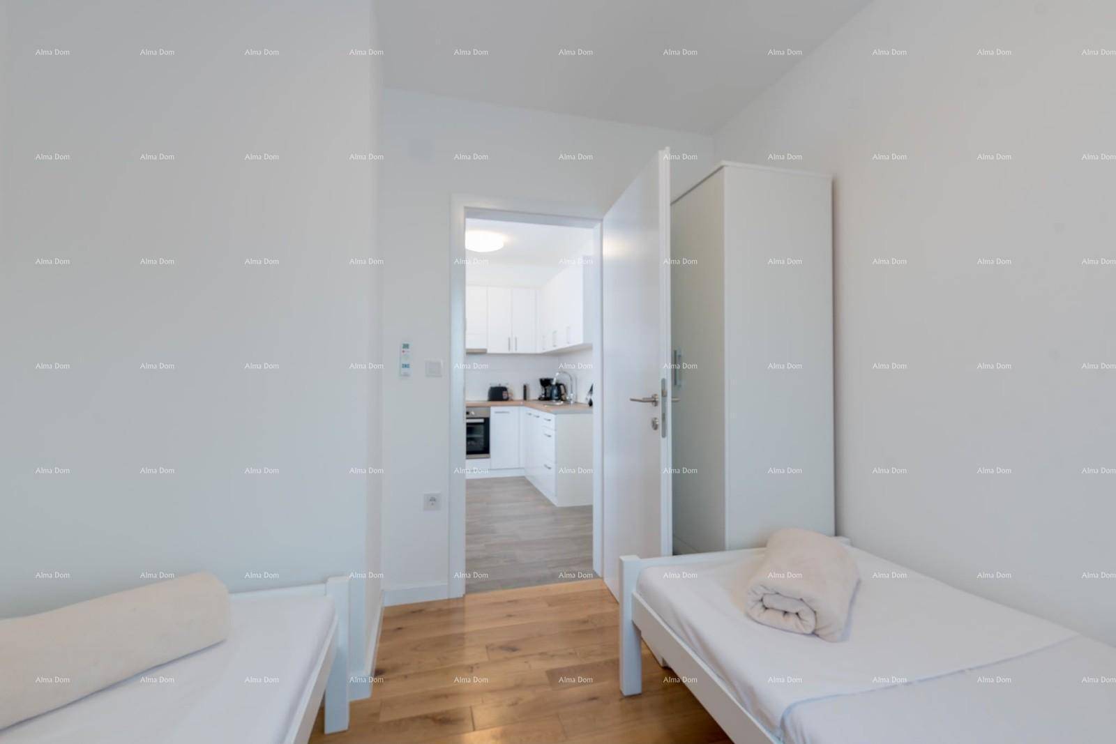 Schlafzimmer mit zwei Einzelbetten und Blick durch die offene Tür zur Küche.