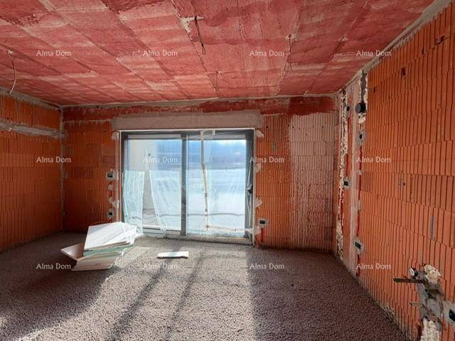 Heller Rohbau mit Ziegelwänden und großem Fenster, bereit für den Innenausbau.