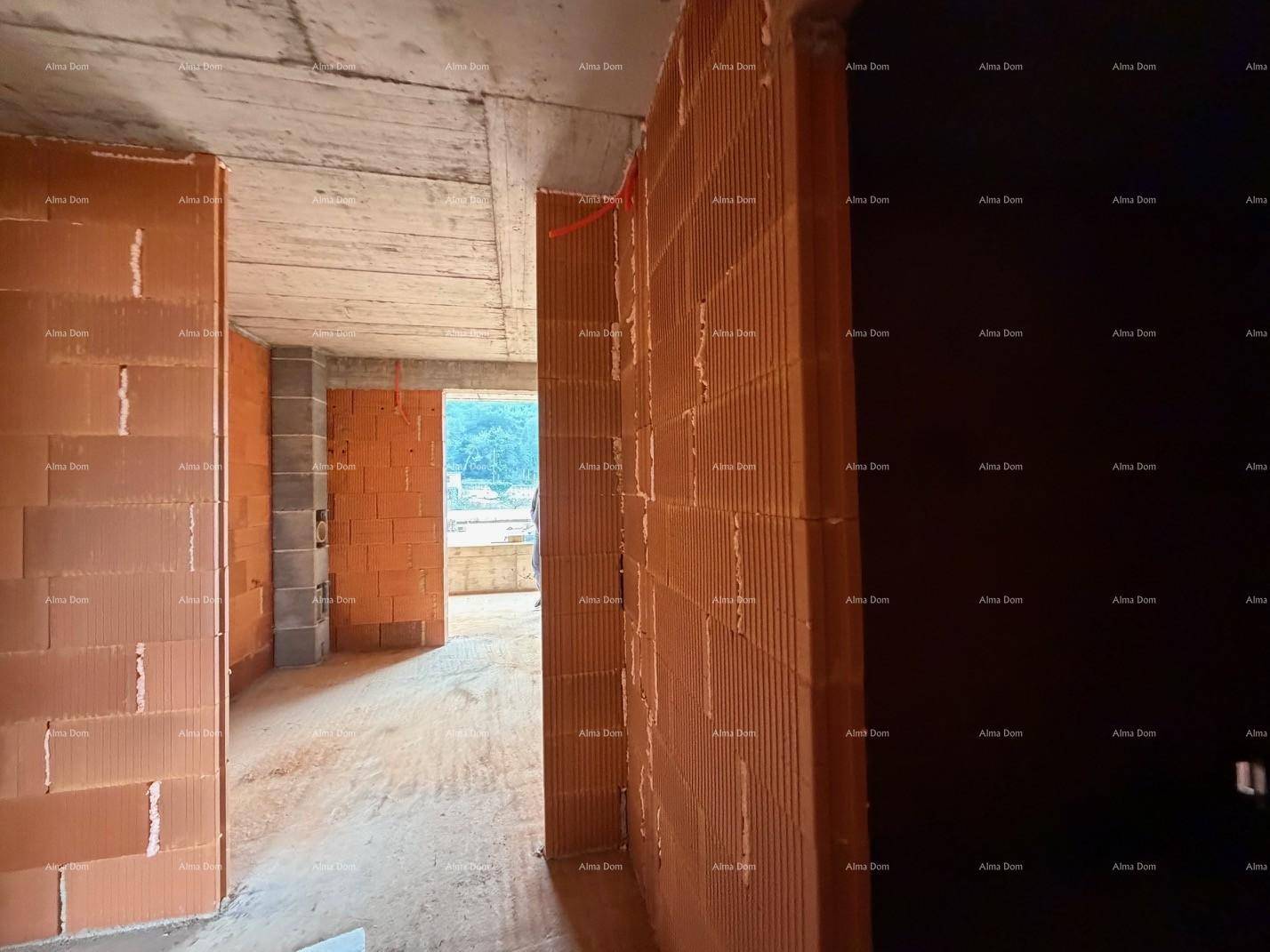 Unfertiger Flurbereich mit Ziegelwänden und Betonboden, der die Struktur des Gebäudes zeigt.
