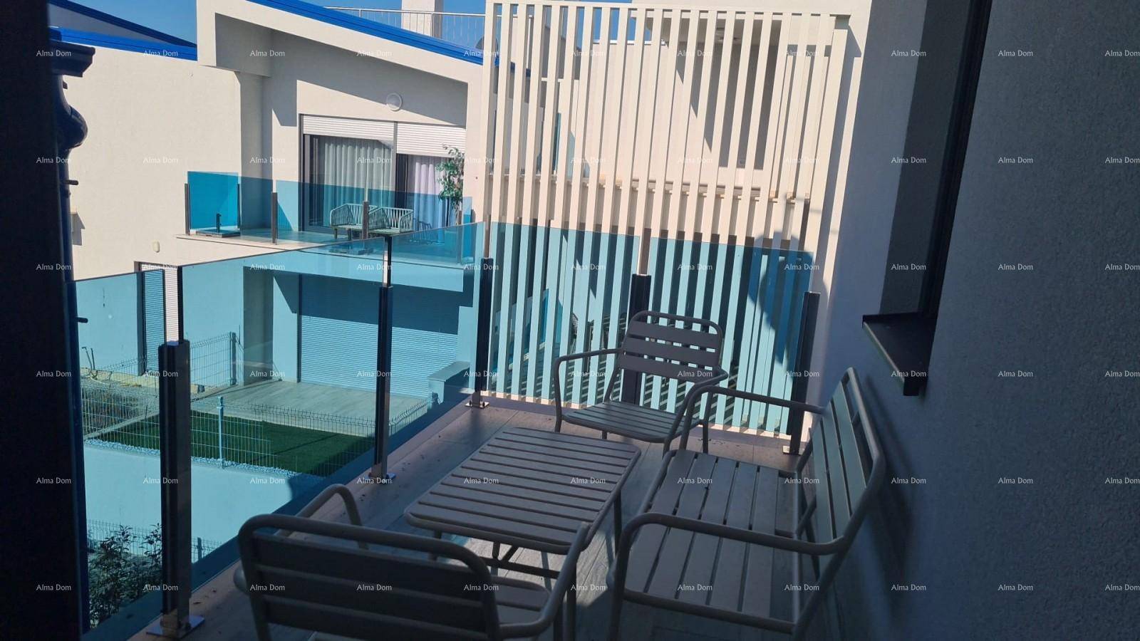 Möblierter Balkon mit Glasgeländer und Blick auf weitere Balkone der modernen Wohnanlage.