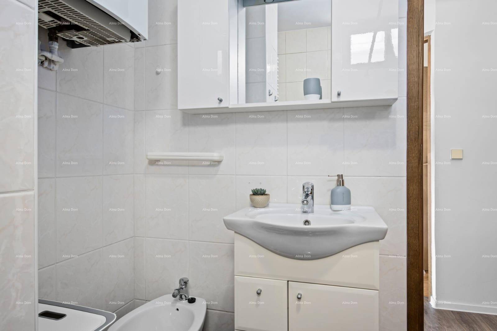 Modernes Badezimmer mit Waschbecken, Spiegelschrank und Bidet, in hellen Fliesen gehalten.