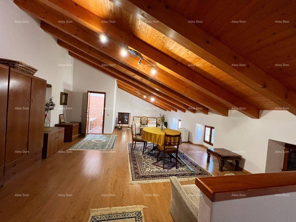 Weitläufiger Dachboden mit Holzbalkendecke, Schlaf- und Wohnbereich und Teppichen.