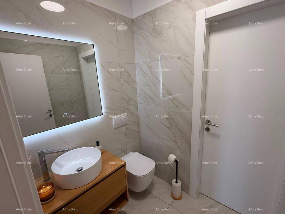 Modernes Badezimmer mit schwebendem Waschtisch, Aufsatzwaschbecken und beleuchtetem Spiegel.