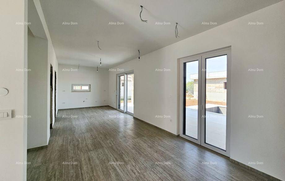 Heller, leerer Wohnraum mit großen Glastüren, die viel Tageslicht hereinlassen und Zugang nach draußen bieten.