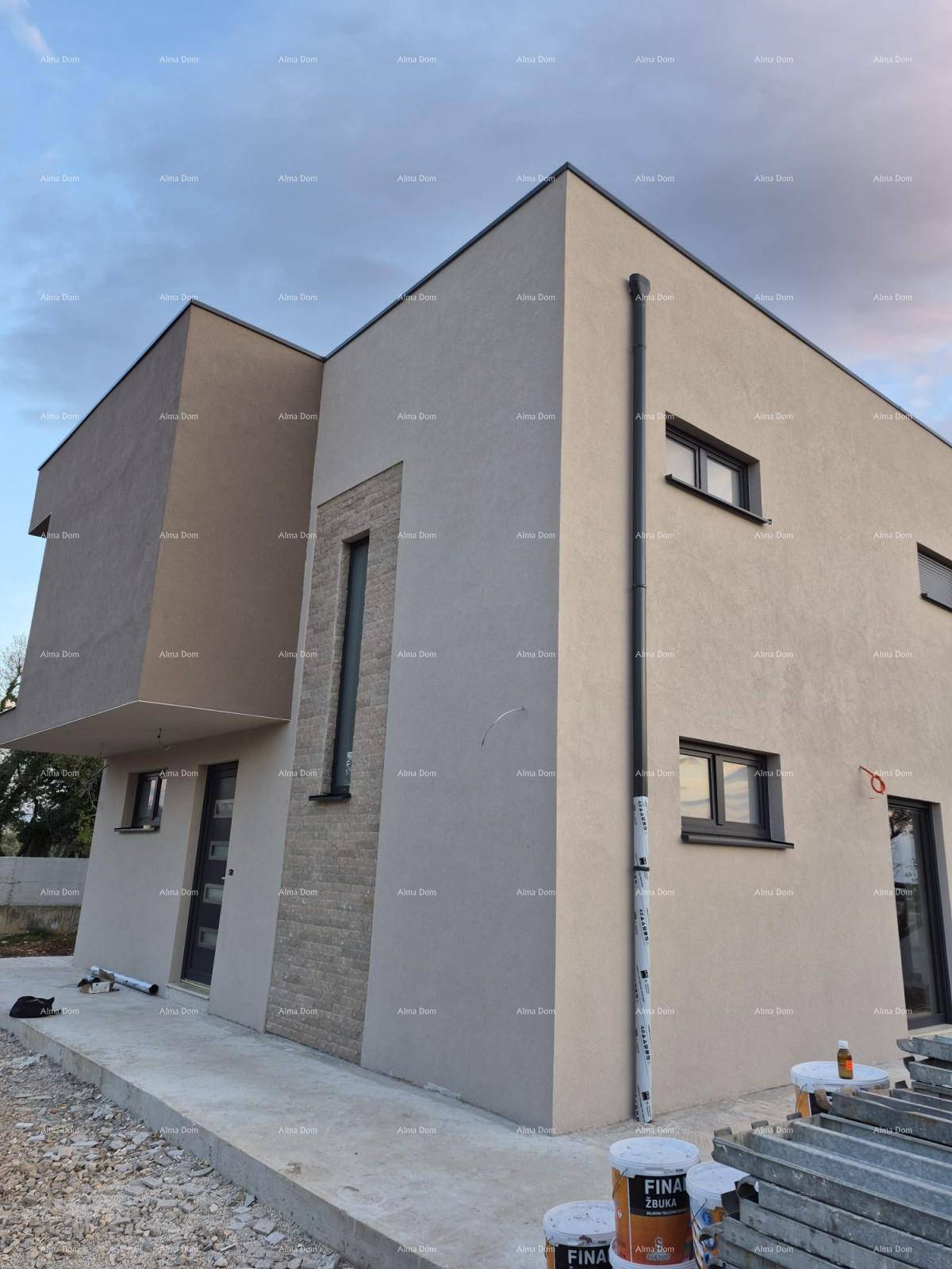 Seitenansicht eines modernen Hauses im Bau mit Steinfassade und Baumaterialien im Außenbereich.
