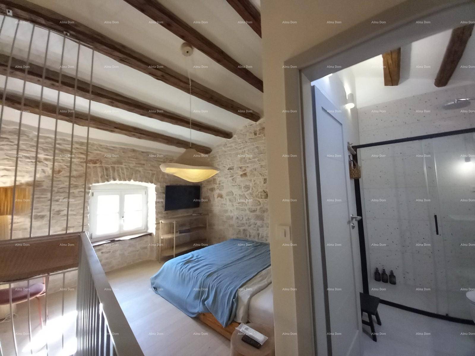 Schlafzimmer im Obergeschoss mit offener Galerie, Steinwänden und Holzbalkendecke.