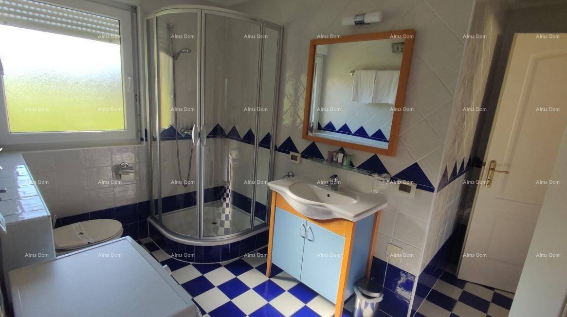 Badezimmer mit Duschkabine, Waschbecken, WC und Bidet, ausgestattet mit blau-weißen Fliesen.
