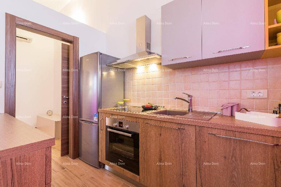 Funktionale Küchenzeile mit Spüle, Kochfeld, Backofen und großem Kühlschrank.