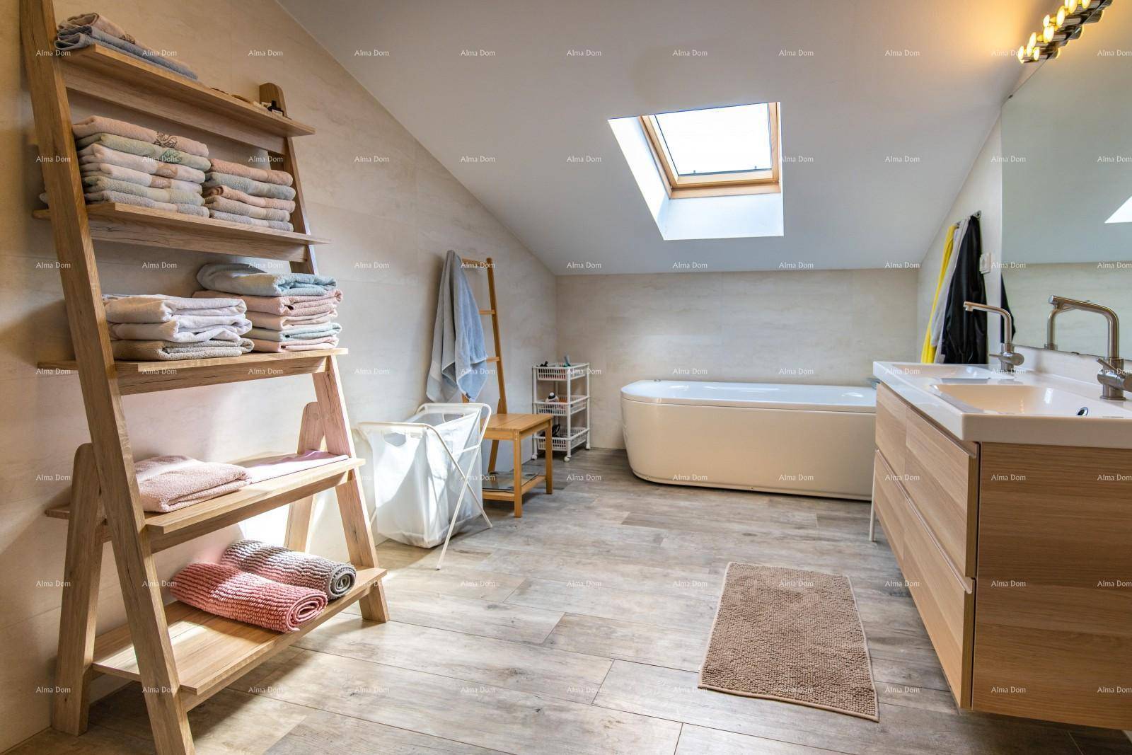 Modernes Badezimmer im Dachgeschoss mit Badewanne, Dachfenster und Holzoptik-Fliesen.