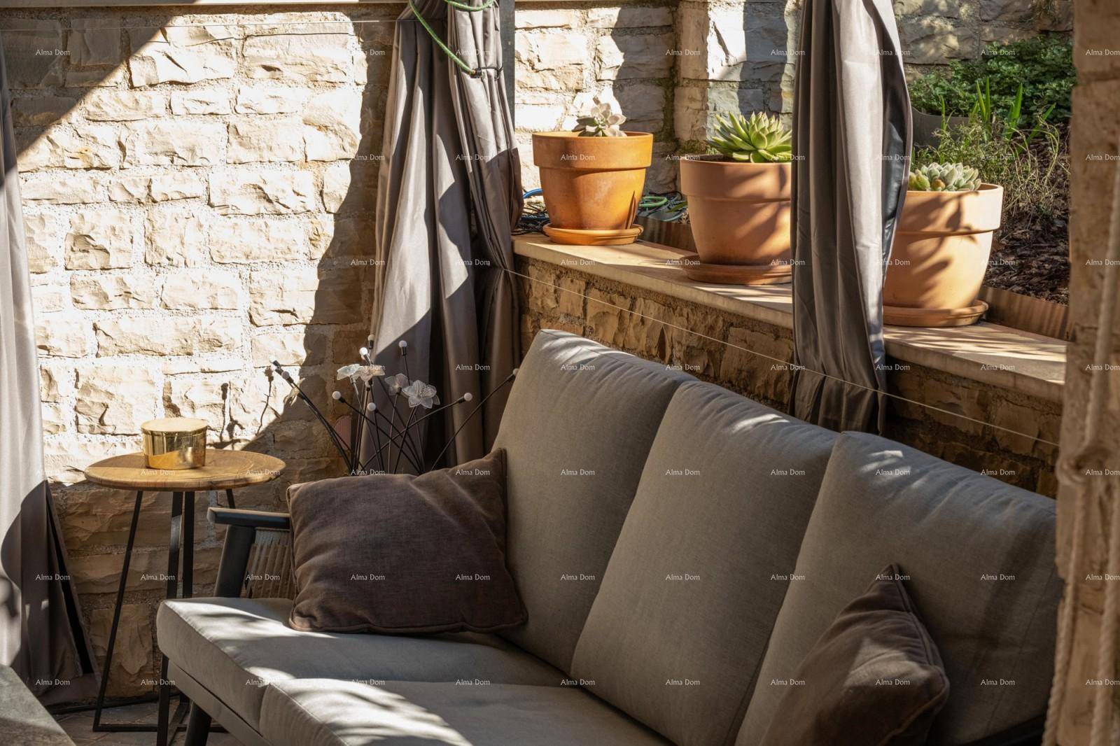 Gemütliche Sitzecke auf der überdachten Terrasse mit Topfpflanzen und Steinmauer.