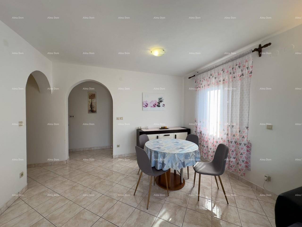 Essbereich des Wohn-Esszimmers mit rundem Tisch, Stühlen und einem Sideboard, Bögen im Hintergrund.