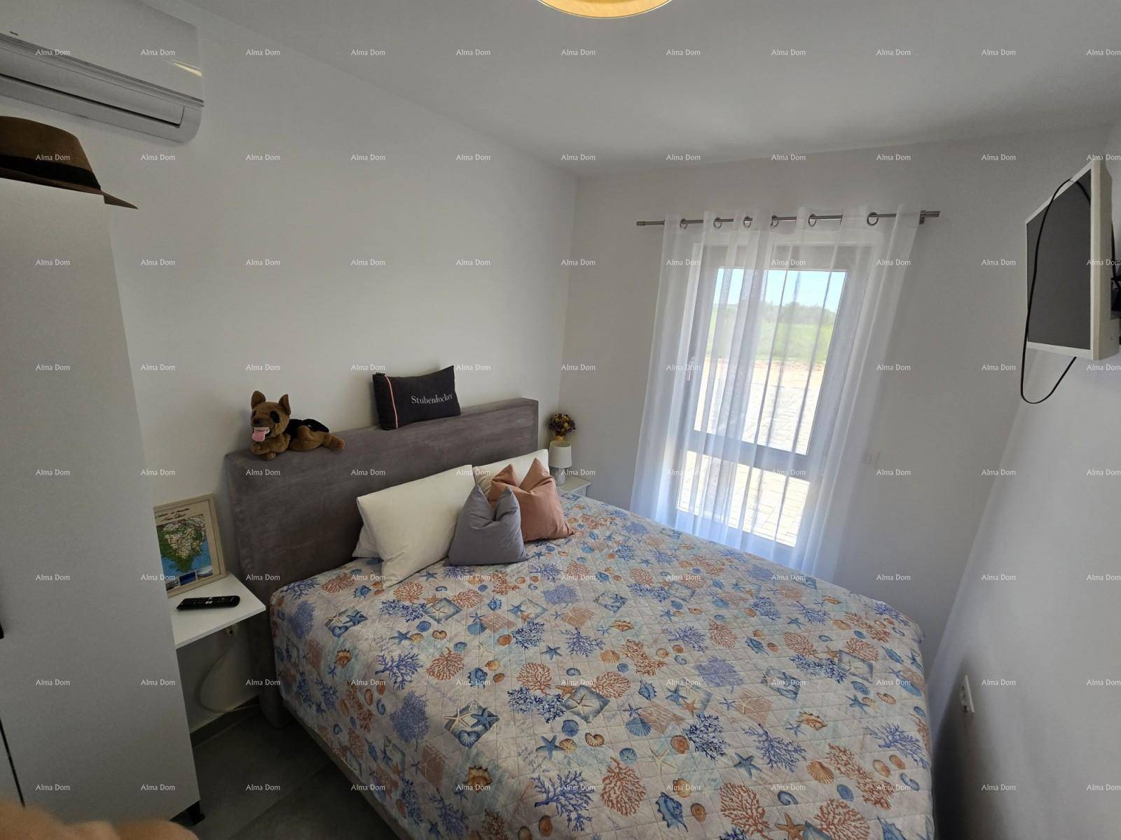 Helles Schlafzimmer mit Doppelbett, Klimaanlage und einem Fenster für natürliches Licht.