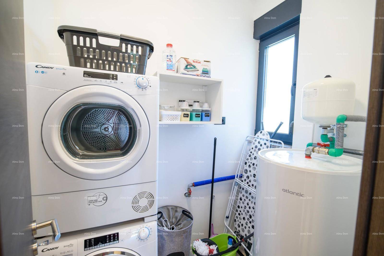 Praktischer Hauswirtschaftsraum mit Waschmaschine, Trockner und Warmwasserbereiter.
