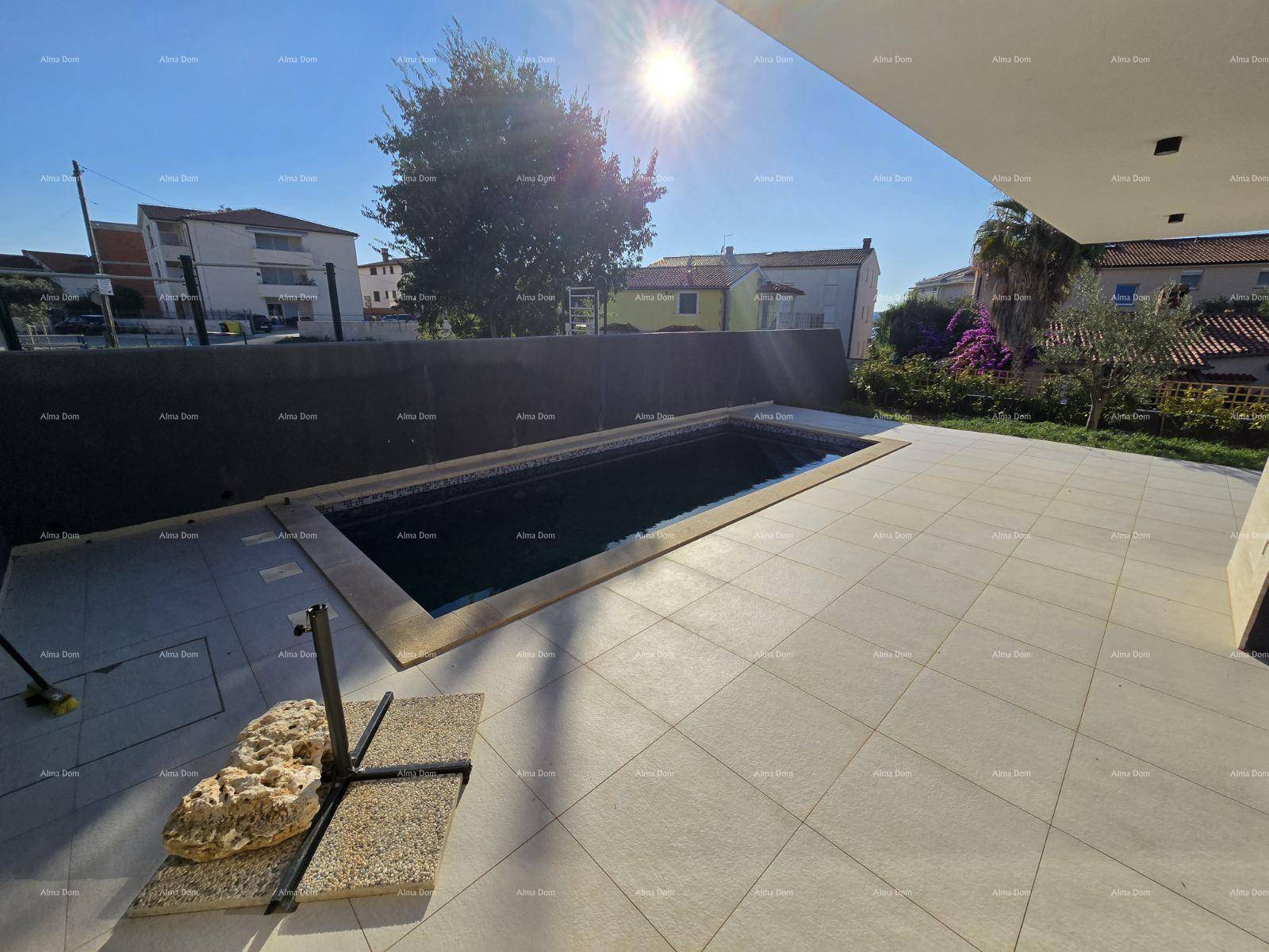 Sonniger Außenbereich mit Pool und Blick auf die umliegende Nachbarschaft und den Himmel.