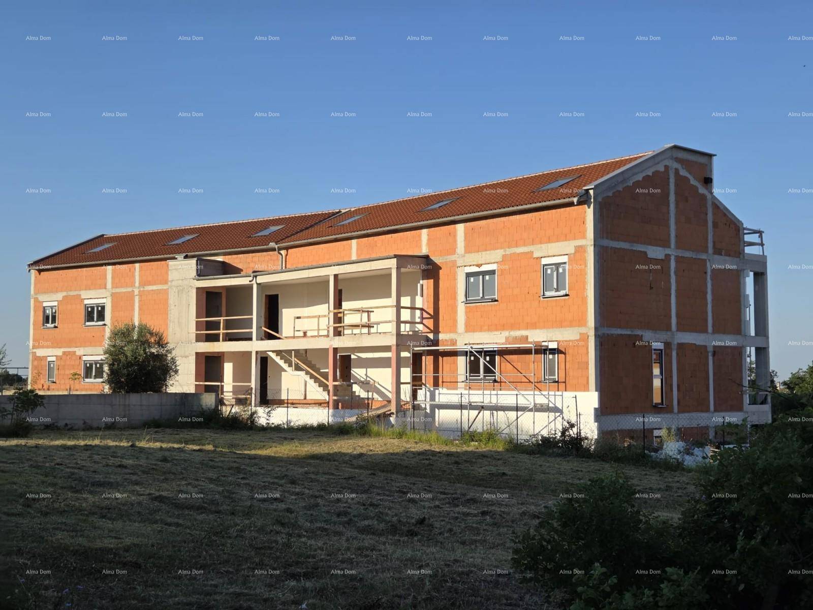Seitenansicht des Neubaus im Rohbau mit unfertigen Balkonen und Dachfenstern.