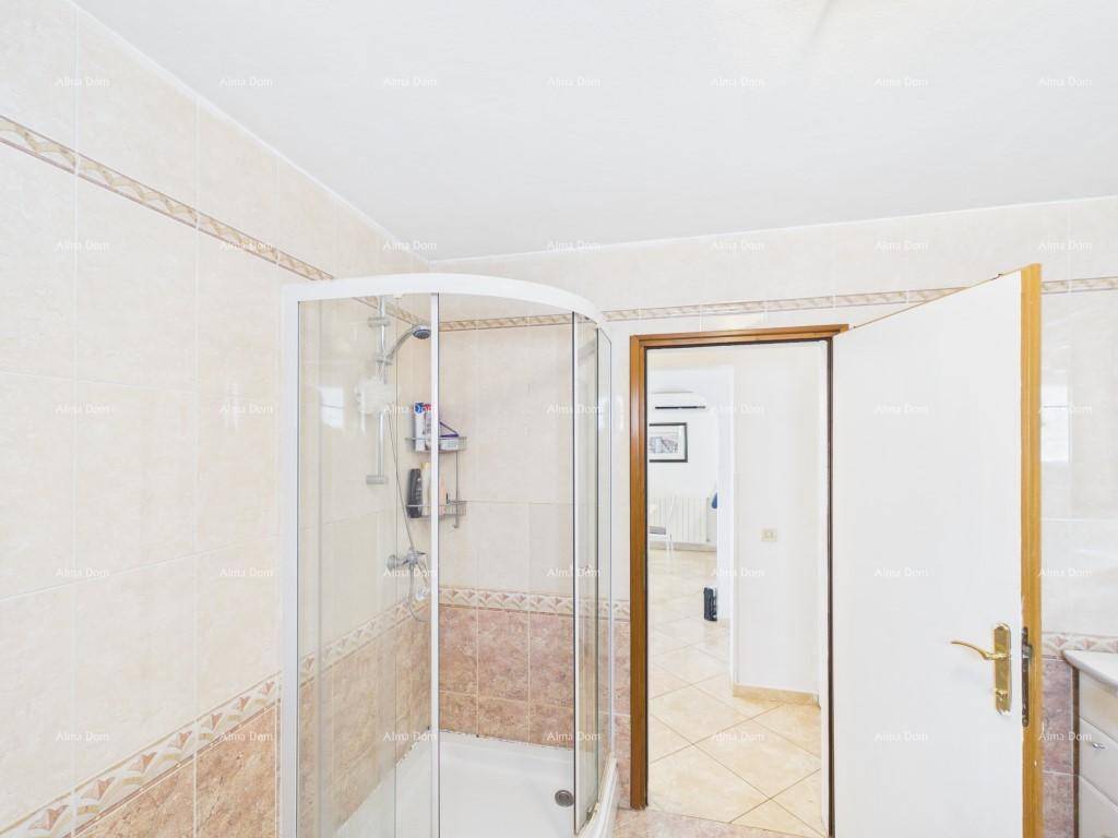 Badezimmer mit einer praktischen Eckduschkabine und hellen Fliesen, die eine saubere Atmosphäre schaffen.