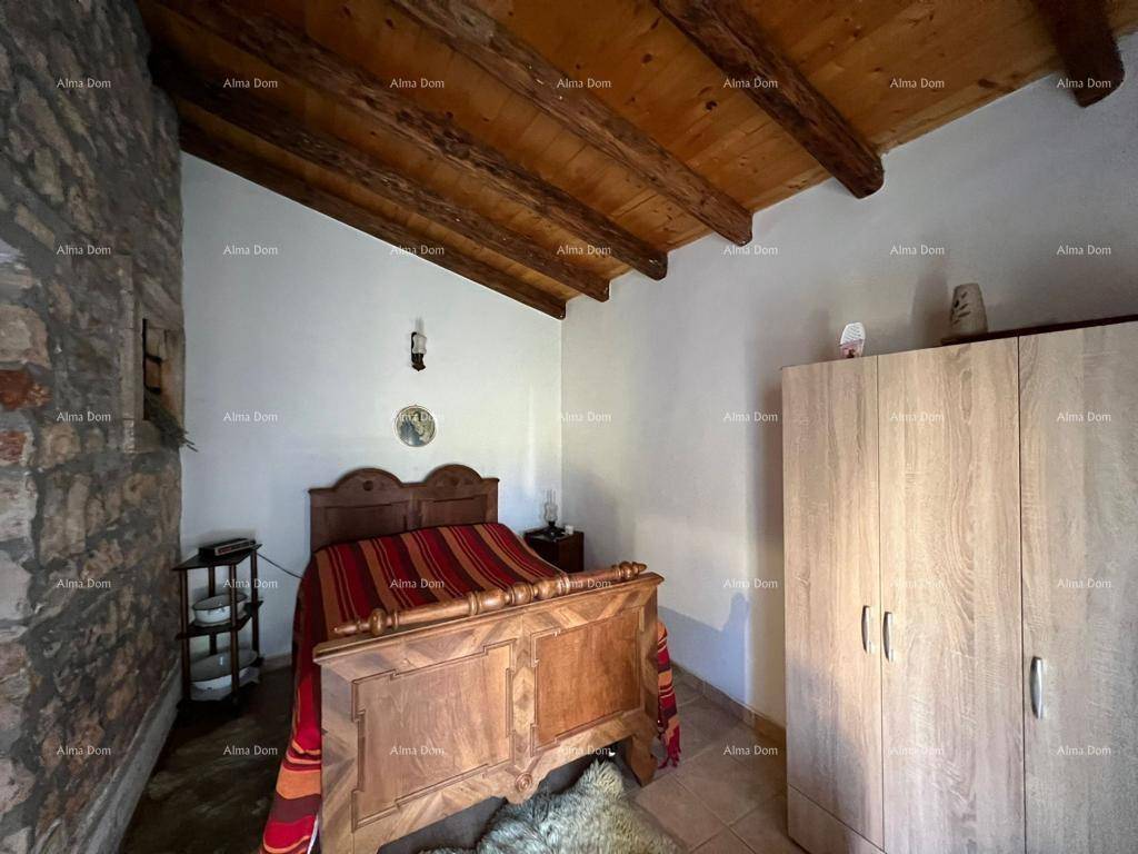 Traditionelles Schlafzimmer mit Holzbalken, Steinwand und klassischem Holzmobiliar.