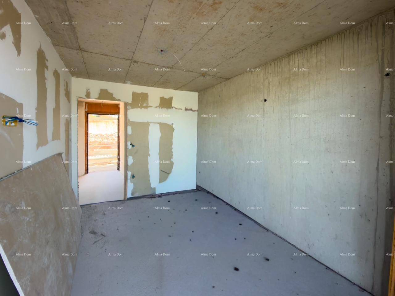 Unfertiger Innenraum mit rohen Betonwänden und einem Durchgang zu einem weiteren Baustellenbereich.