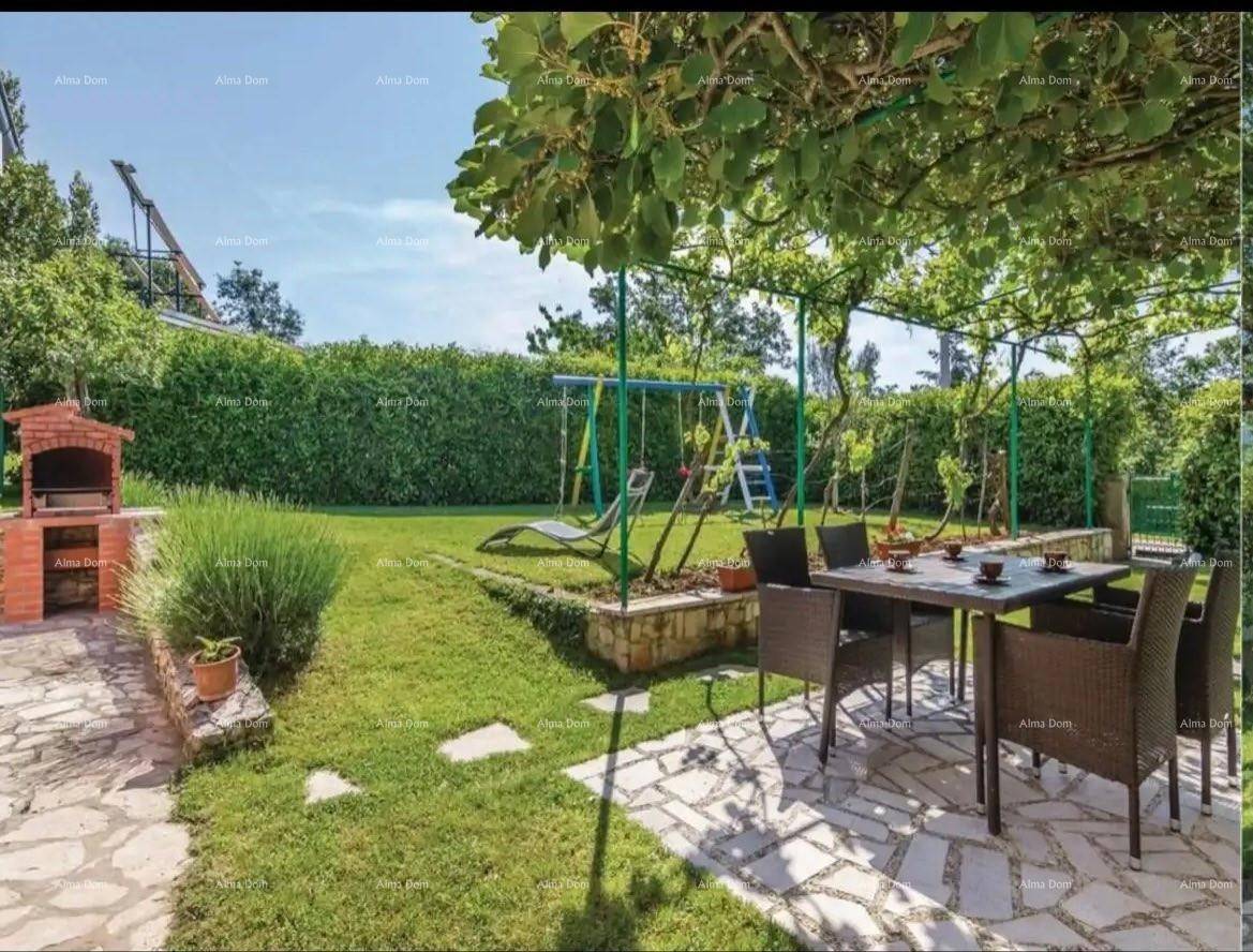 Gemütlicher Essbereich im Freien mit Grill, Schaukel und üppiger grüner Hecke im Garten.