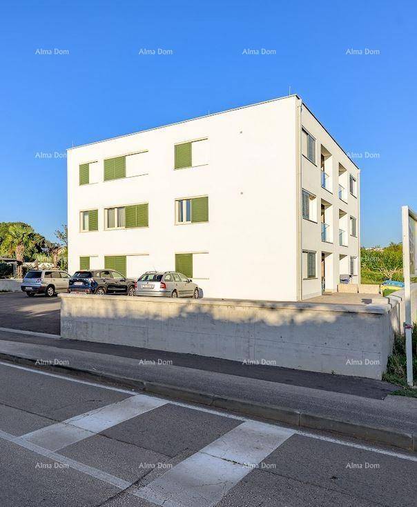 Modernes Wohngebäude mit mehreren Etagen, Parkplätzen und grünen Fensterläden.