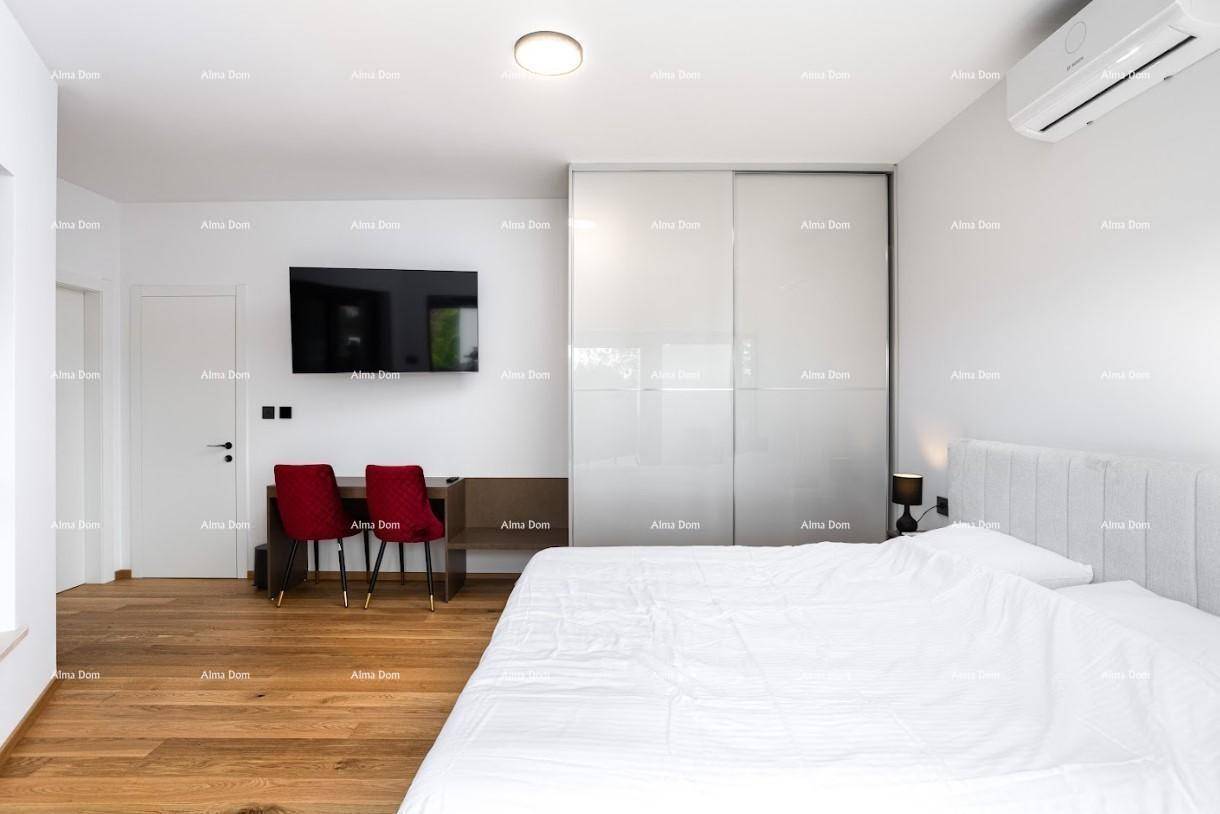 Helles Schlafzimmer mit Holzboden, großem Bett, Schreibtisch und integrierten Schränken.