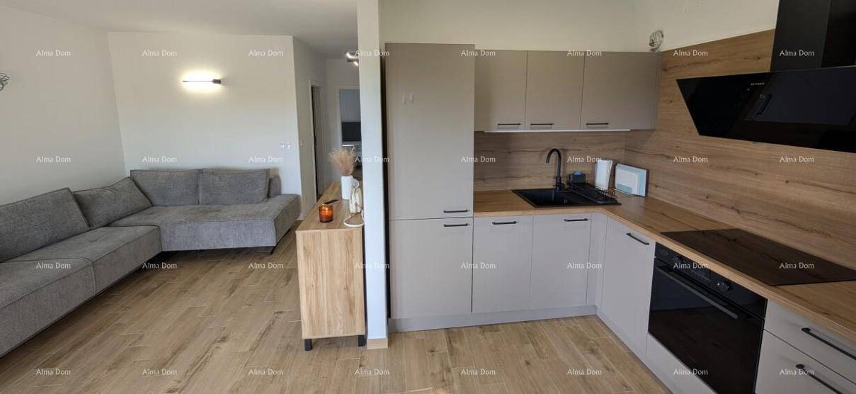 Funktionale Küche mit grauen Schränken und Holztheke im offenen Wohnbereich, gut ausgestattet.