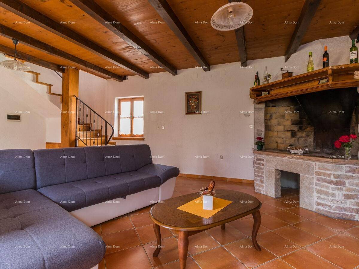 Gemütliches Wohnzimmer mit großem Kamin, Holzbalkendecke und Terrakottafliesen.