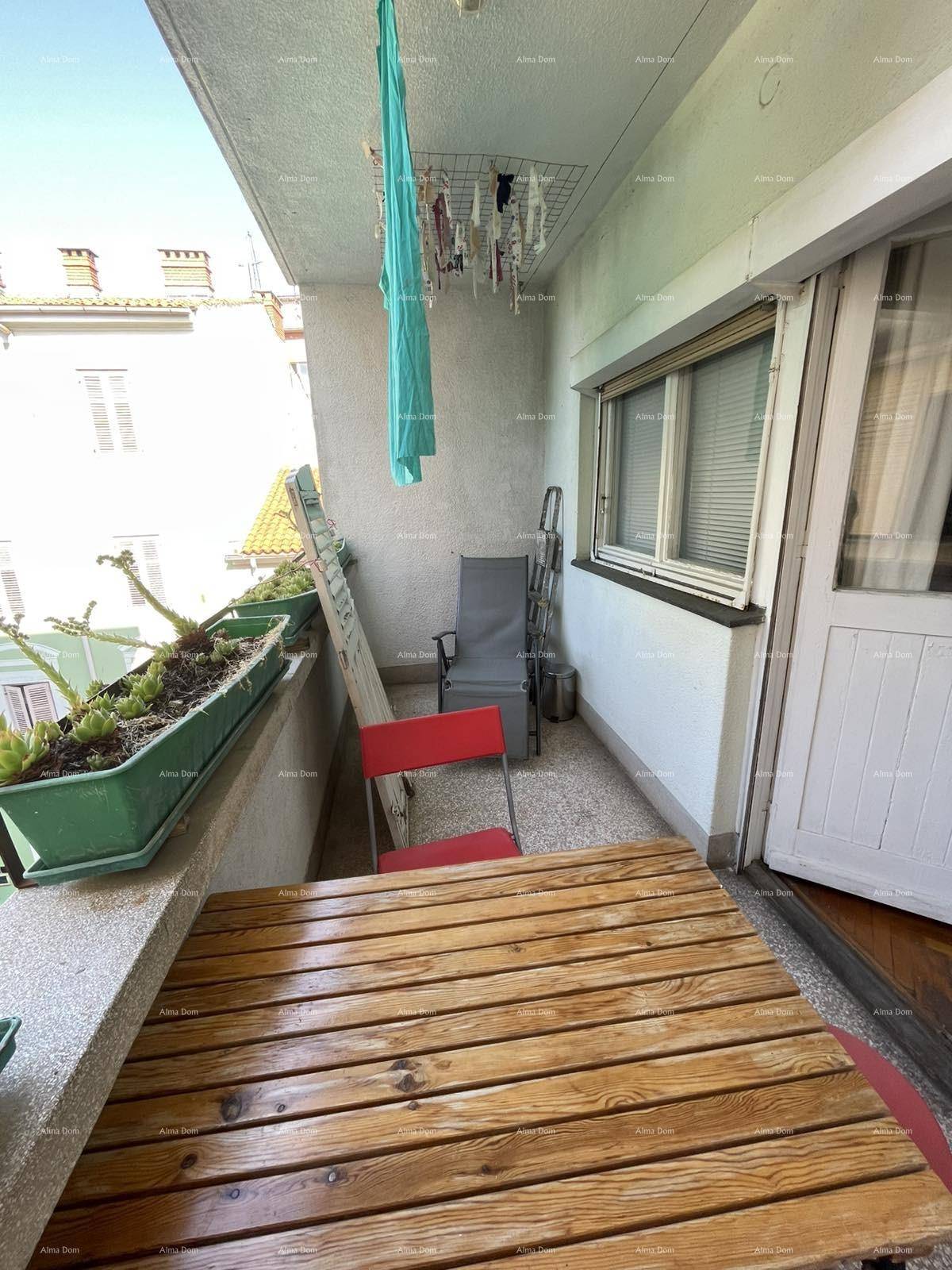 Schmaler Balkon mit Holztisch, Pflanzen und Wäscheständer, ideal für kleine Pausen.