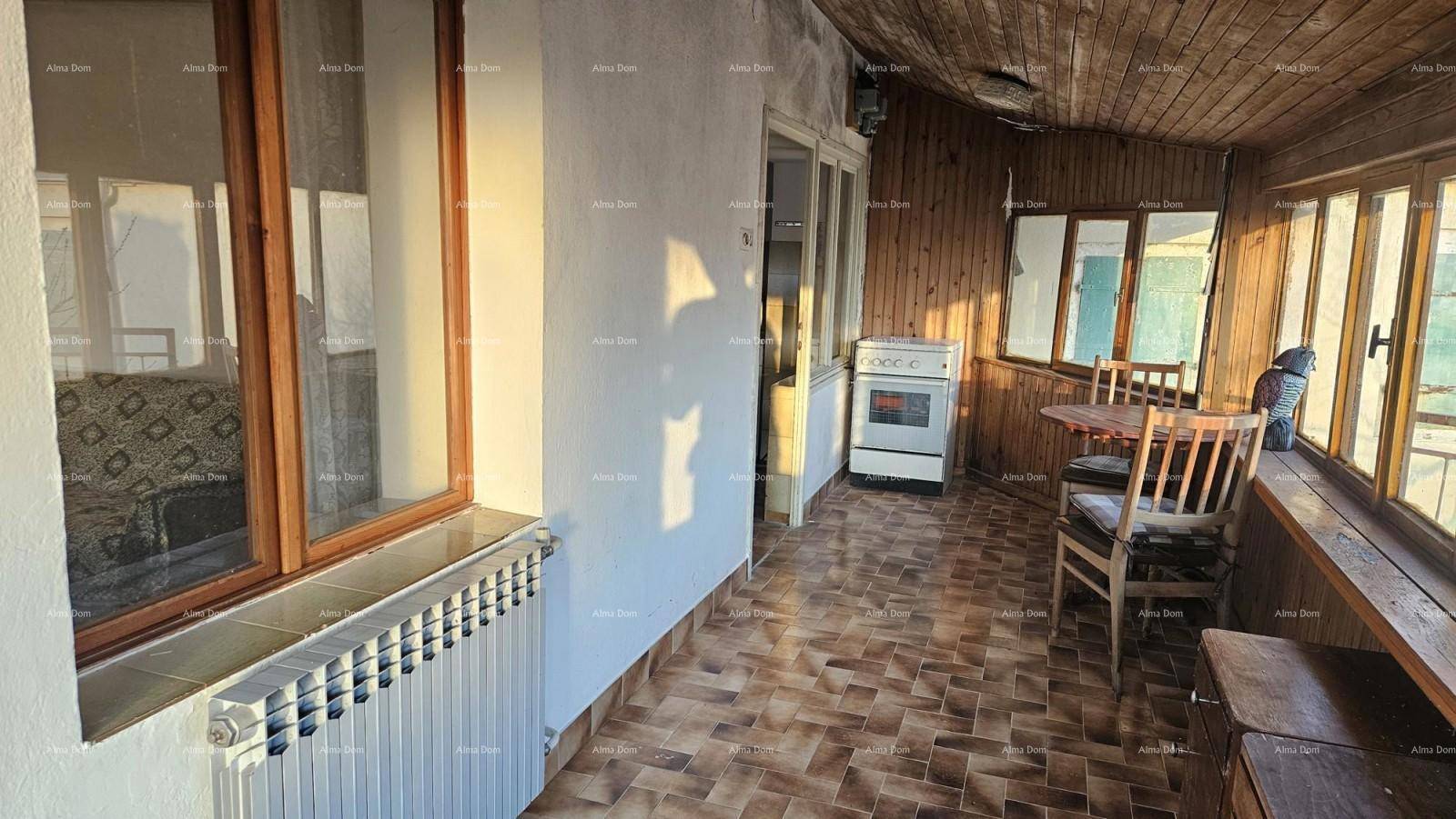 Sonniger Wintergarten mit Holzverkleidung, Fliesenboden und einem kleinen Ofen für zusätzliche Wärme.