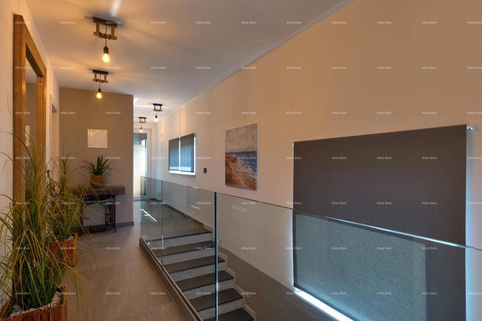 Heller Flur mit moderner Treppe, Glasgeländer und dekorativen Pflanzen.