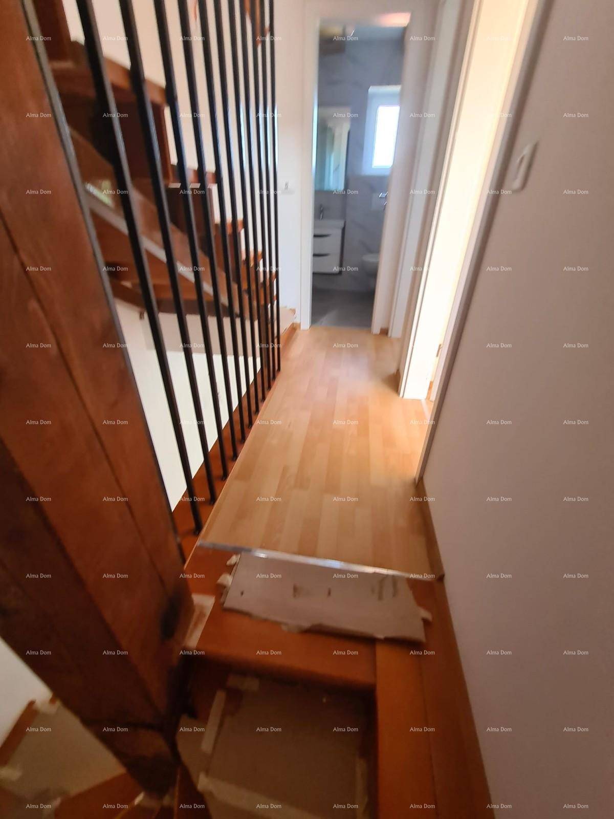 Heller Flur im Obergeschoss mit Laminatboden und Zugang zum Badezimmer.