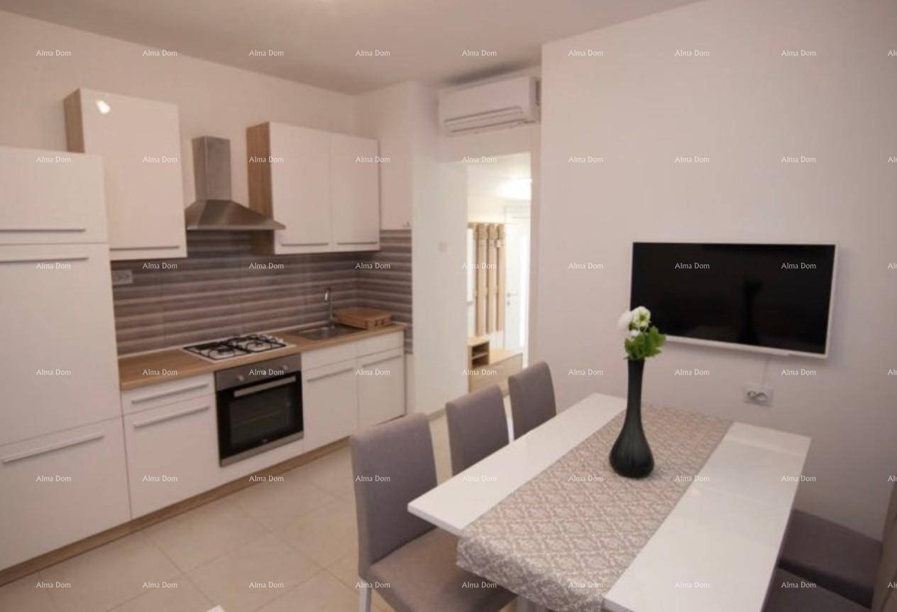 Moderne Küche mit weißen Schränken, integriertem Backofen und Essbereich mit Wandfernseher.