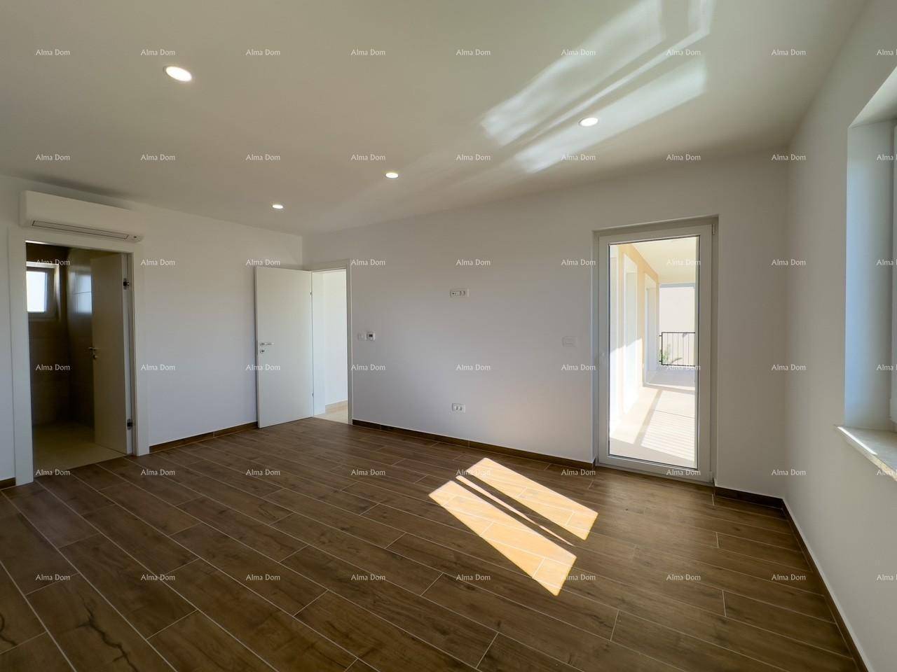 Helles Zimmer mit Holzfliesenboden, Klimaanlage und Zugang zu einem Balkon oder einer Terrasse.