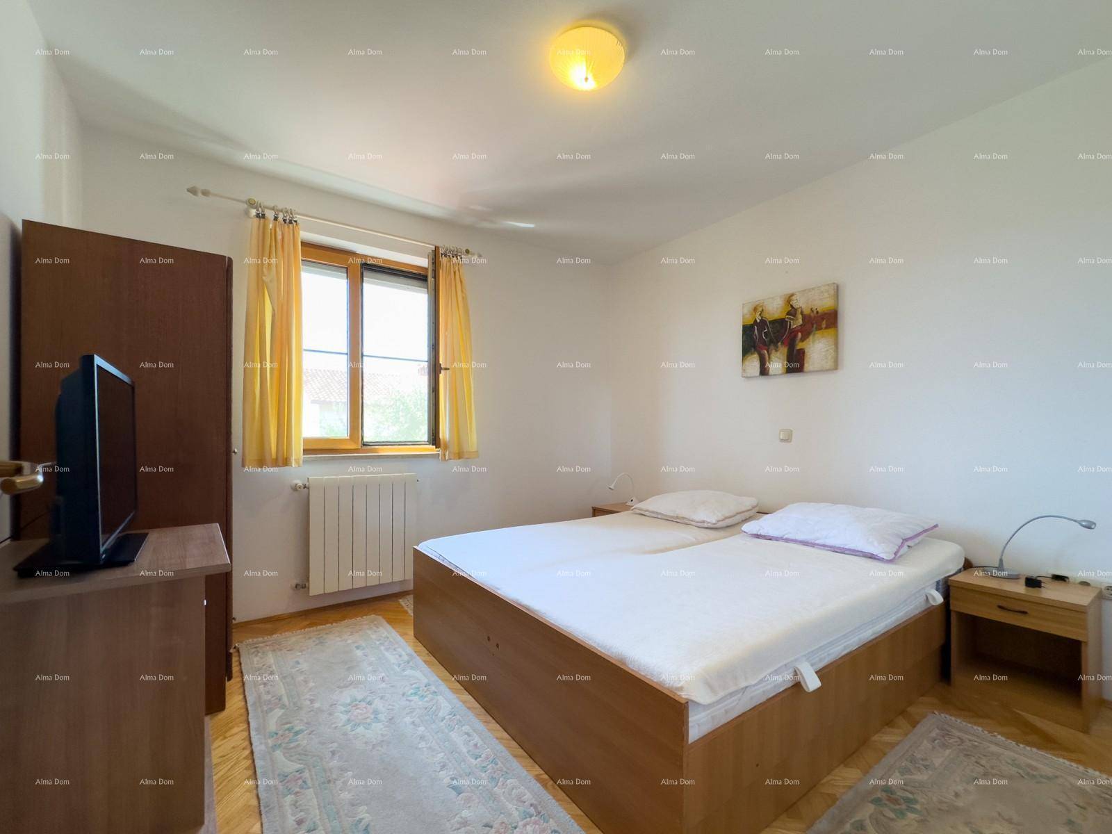 Helles Schlafzimmer mit Doppelbett, Holzschrank und Parkettboden, gut beleuchtet.