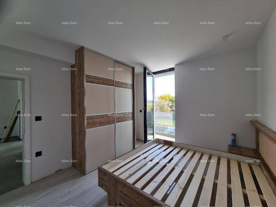 Schlafzimmer mit Holzbettrahmen, Einbauschrank und Zugang zu einem Balkon.