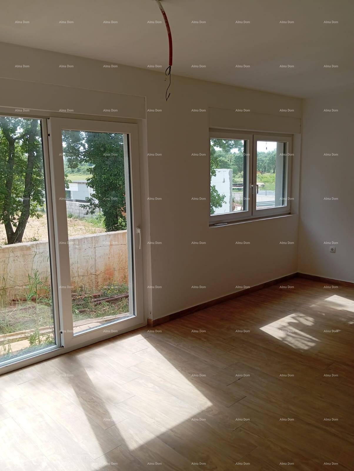 Heller Wohnraum mit Holzoptik-Fliesenboden und großen Fenstern mit Blick ins Grüne.