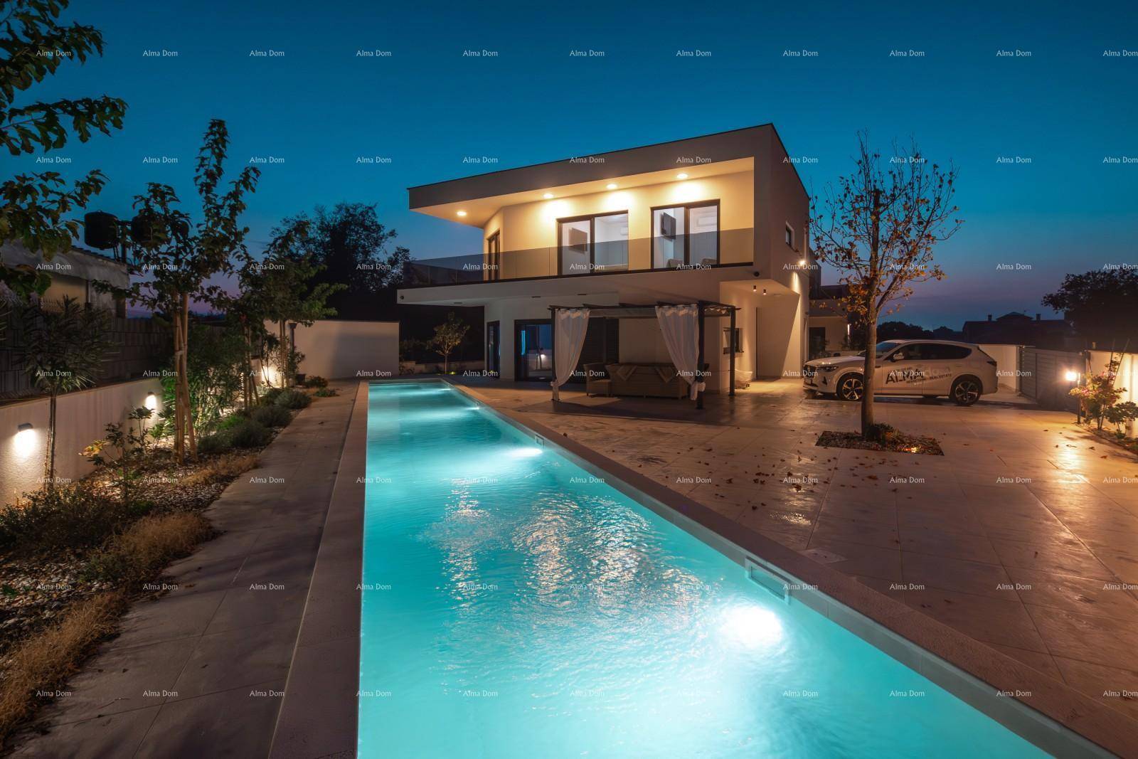 Beleuchteter Poolbereich und die moderne Villa bei Nacht mit angrenzendem Parkplatz.
