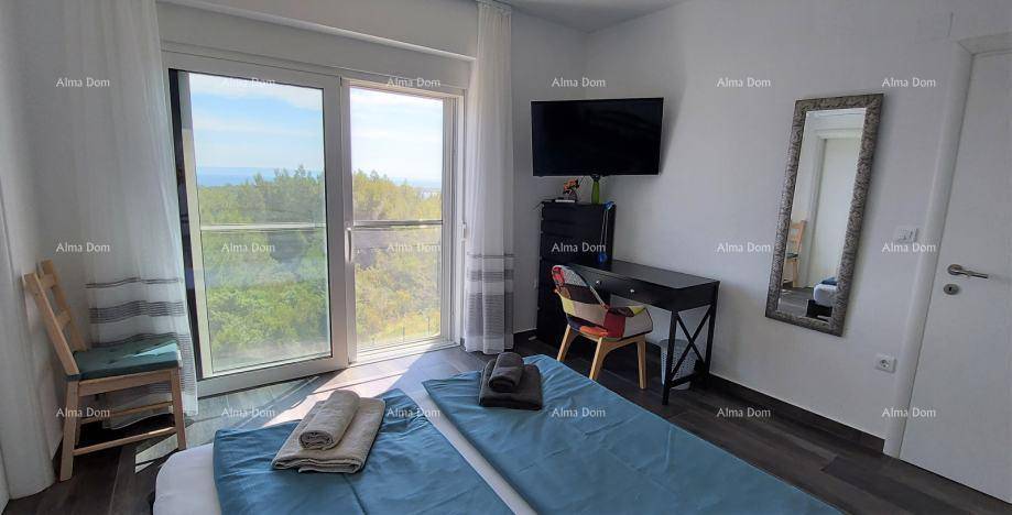 Modernes Schlafzimmer mit Doppelbett, Schreibtisch, Fernseher und großen Fenstern mit schöner Aussicht.