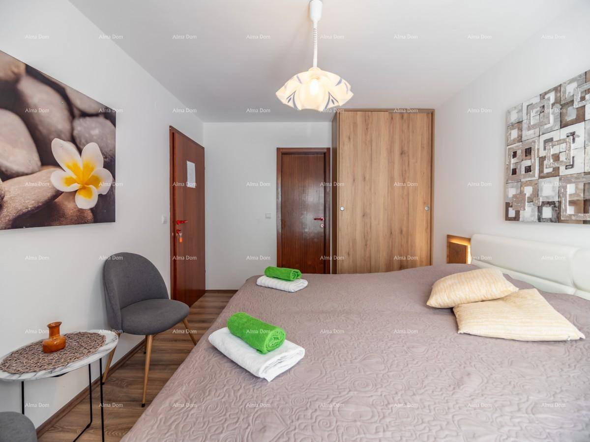 Schlafzimmer mit Doppelbett, großem Holzschrank, Holzboden und moderner Wandkunst.