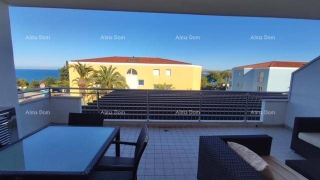 Großzügige Terrasse mit Lounge- und Essbereich, bietet entspannte Stunden unter blauem Himmel mit Meerblick.